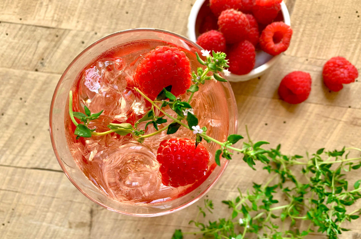 A rosé thyme wine cooler in a glass with ice, created by chef Megan Mitchell.