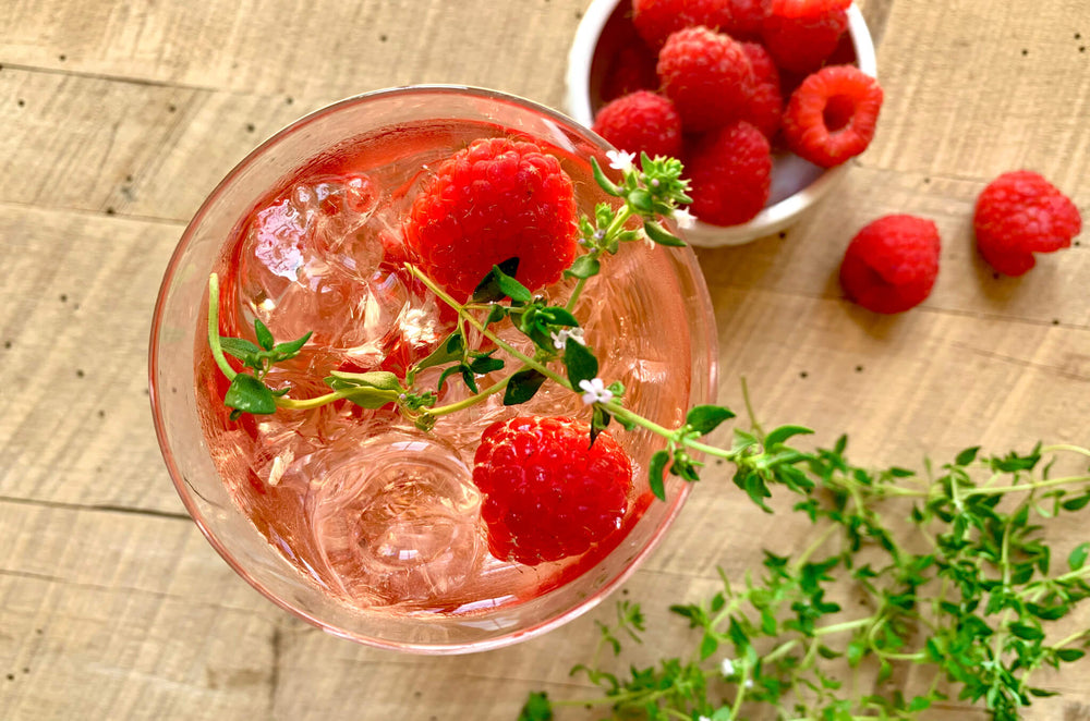 A rosé thyme wine cooler in a glass with ice, created by chef Megan Mitchell.