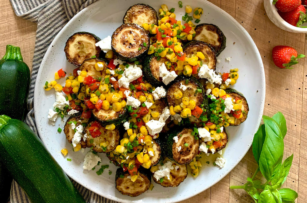 A plate of zucchini crisped up in olive oil and topped off with a sweet corn relish.