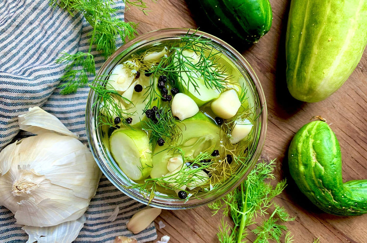A glass jar full of garlic and dill pickles