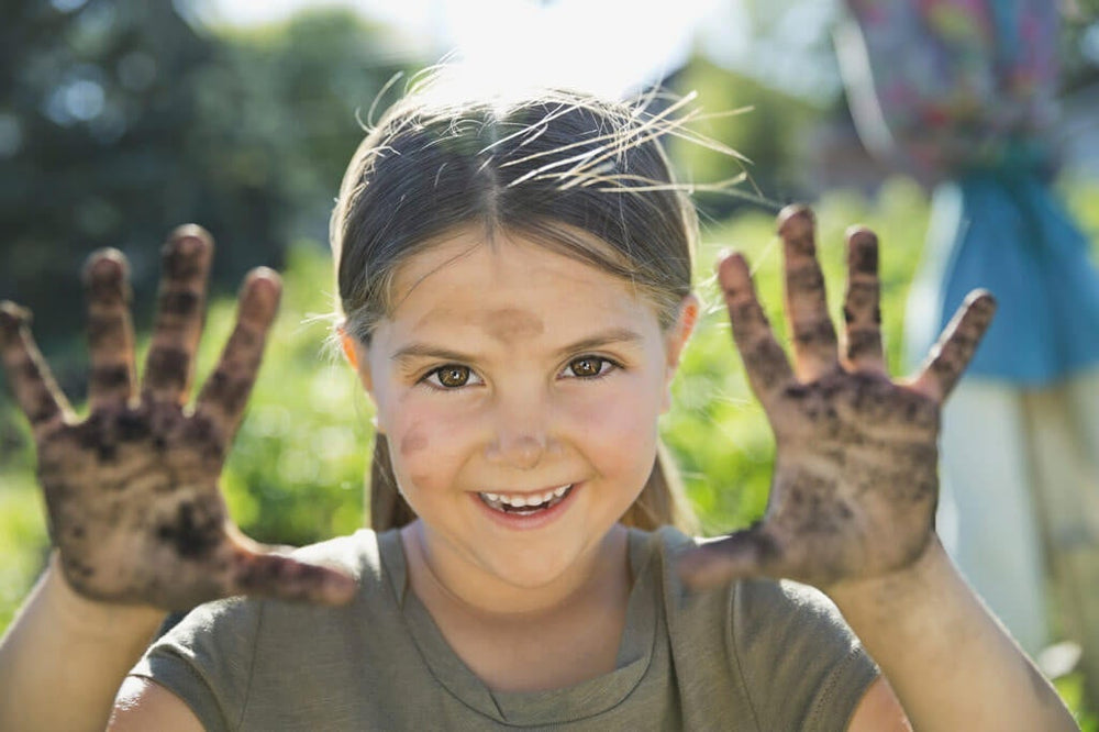 garden games: happy girl with dirty hands